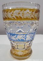 Front view of Bohemian cut crystal vase showing amber, clear, and blue cut color bands with floral and geometric motifs.