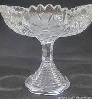 Side view showing floral etching and sawtooth scalloped edge on the compote bowl.