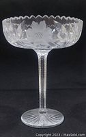 Full view of vintage crystal compote showing the bowl with floral and leaf engravings and scalloped rim.