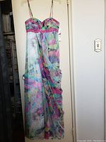 Full view of the colorful ankle-length dress showcasing its light fabric, fitted top with beaded waist detail, spaghetti straps, and flowing skirt.