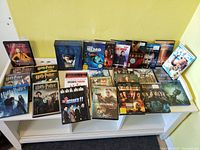 Photo showing 19 DVD movie cases including Harry Potter multi-set, Ice Age, Finding Nemo, Pirates of the Caribbean, Bourne series, and other popular films