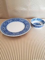 Porcelain plate and bowl set displayed on striped surface, showing both items side by side