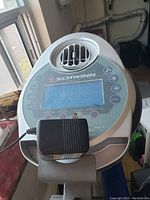 Close-up of the LCD screen display panel and control buttons with power adapter plugged in on the Schwinn bike.