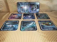 Photo showing the 10 Star Trek coasters spread out on a striped fabric surface, featuring various starships and series logos.