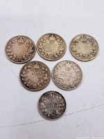 Six Canadian silver coins showing the reverse side with denominations (five 10 cents and one 5 cents coin) and wreath/crown designs, visible wear and tarnish.