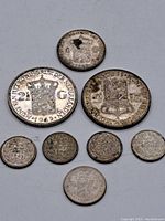 Seven silver coins arranged with three 2 1/2 Gulden coins and four 25 Cent coins, showing worn surfaces and date markings.