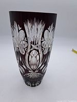 Front view of the ruby red crystal vase showing floral and geometric cut pattern details.