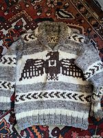 Full view of front of hand-knit Cowichan style wool sweater showing Thunderbird motif and shawl collar
