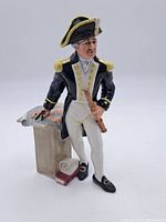 Front view of the figurine showing the captain in uniform with telescope and map on pedestal