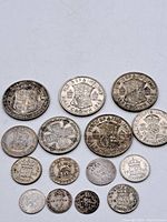 Full lot of 14 vintage silver British coins including Half Crowns, Shillings, Sixpences, and pennies laid out in multiple rows showing obverse and reverse designs.