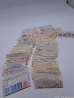 Photo showing numerous translucent sleeves each labeled with country names containing assorted postage stamps