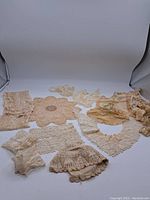 Collection of vintage lace items including cuffs, collars, and antique hat displayed together to show all contents.