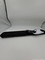 Front view of soundbar with remote control and power cable placed on top