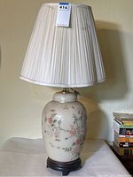 Full view of ceramic table lamp with pleated fabric shade on top, measuring about 31 inches tall.