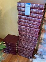 Stack of Encyclopedia Britannica volumes in maroon hardcover with gold embossed text and numbering