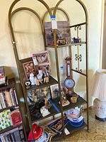 Full front view of metal knick knack shelf with various decorative items on shelves.