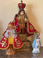 Wide view showing all three vintage religious figurines together on a surface.