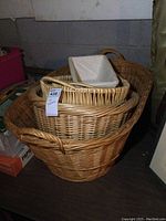 Five wicker baskets stacked inside each other, showing the varying sizes and shapes, largest basket measured roughly 31x22x13 inches.