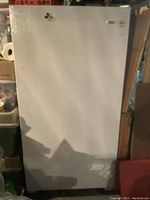 Front view of white upright freezer, showing full height and door.