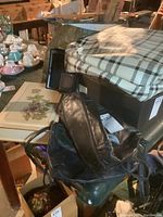 Photo shows a black leather SAS shoulder bag, a dark green Naturalizer leather bag, and a beige floral notebook set. Also visible is part of a green jewelry box with zipper.