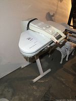 Left side angle view of Euro-Pro electronic steam press on stand, showing the padded ironing surface and overall structure.