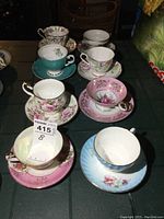 Front angle of all 8 vintage teacups and saucers showing different floral patterns and color accents.