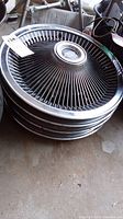 Stack of four radial spoke hubcaps with Riviera center medallion