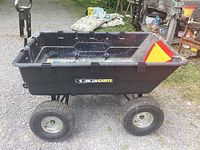 Full side view of Gorilla Carts tipping cart showing the plastic cargo bed, four wheels, and pull handle.