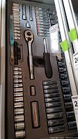 Drawer with assorted sockets, ratchet wrench, screwdriver, and extensions organized in molded tray.