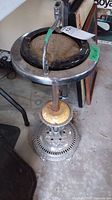 Full view of vintage metal ashtray holder with glass ashtray on top, showing stand, holder ring, and glass ashtray.