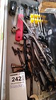 Photo showing a drawer with a variety of wrenches including combination and adjustable wrenches along with pipe wrenches and plastic holders.