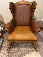 Front view of a large rocking chair showing leather upholstery and wooden frame.