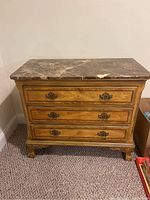 Wood chest with marble top and three drawers, showing exterior front view