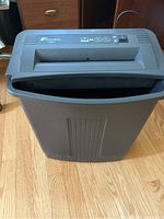 Front angled top view of the black Fellowes DM-3 paper shredder showing shred slot, power switch, and body shape.