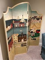 Overall angled view showing three-panel divider with painted seaside village motif