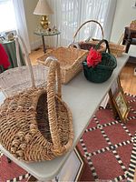 View of seven wicker baskets in different shapes, sizes, and colors on a table.