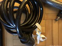 Close-up of black coiled cable bicycle lock showing locking mechanism and key insertion end.