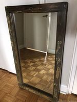 Mirror with rustic wooden farmhouse window-style frame showing distressed paint and wood grain.