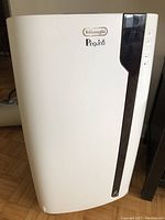 Front view of white DeLonghi Pinguino portable air conditioner with black side trim and DeLonghi logo