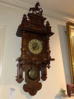 Full view of entire carved wood wall clock mounted on wall