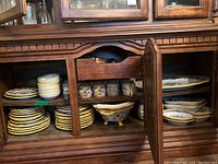 Shelved display of multiple ceramic plates, bowls, mugs, serving pieces