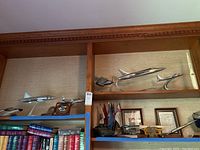Overview of shelf showing multiple metal model aircraft and plaques