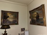 Both paintings hung side by side on wall above furniture