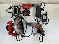 Full set of 5 assorted power tools: Skilsaw circular saw, Milwaukee drill, Bosch angle grinder, Skil drill, and Arrow staple gun, all corded.