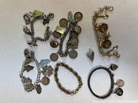 Overview of all 6 bracelets laid out on white surface showing charm details and different styles/colors.