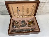 Open jewelry box showing assortment of fashion jewelry pieces inside