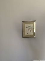 Photo of framed abstract artwork featuring a bird on a branch with red berries.