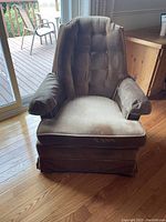 Front view of the beige/brown corduroy rocking arm chair showing tufted backrest, padded armrests, and skirted bottom.