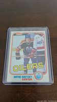 Front of 1981-82 Wayne Gretzky Topps hockey card in plastic protective case showing player image and Oilers team branding