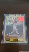 Front view of Barry Bonds rookie card showing the full card with protective plastic sleeve and red RC label.